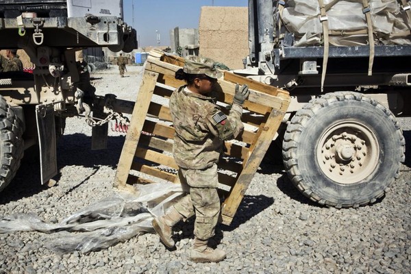 Hạ sĩ nghiệp vụ Joanne Read giúp đỡ bốc dỡ hàng hóa trên xe tải chở thiết yếu phẩm tại quận Maiwand, tỉnh Kandahar.